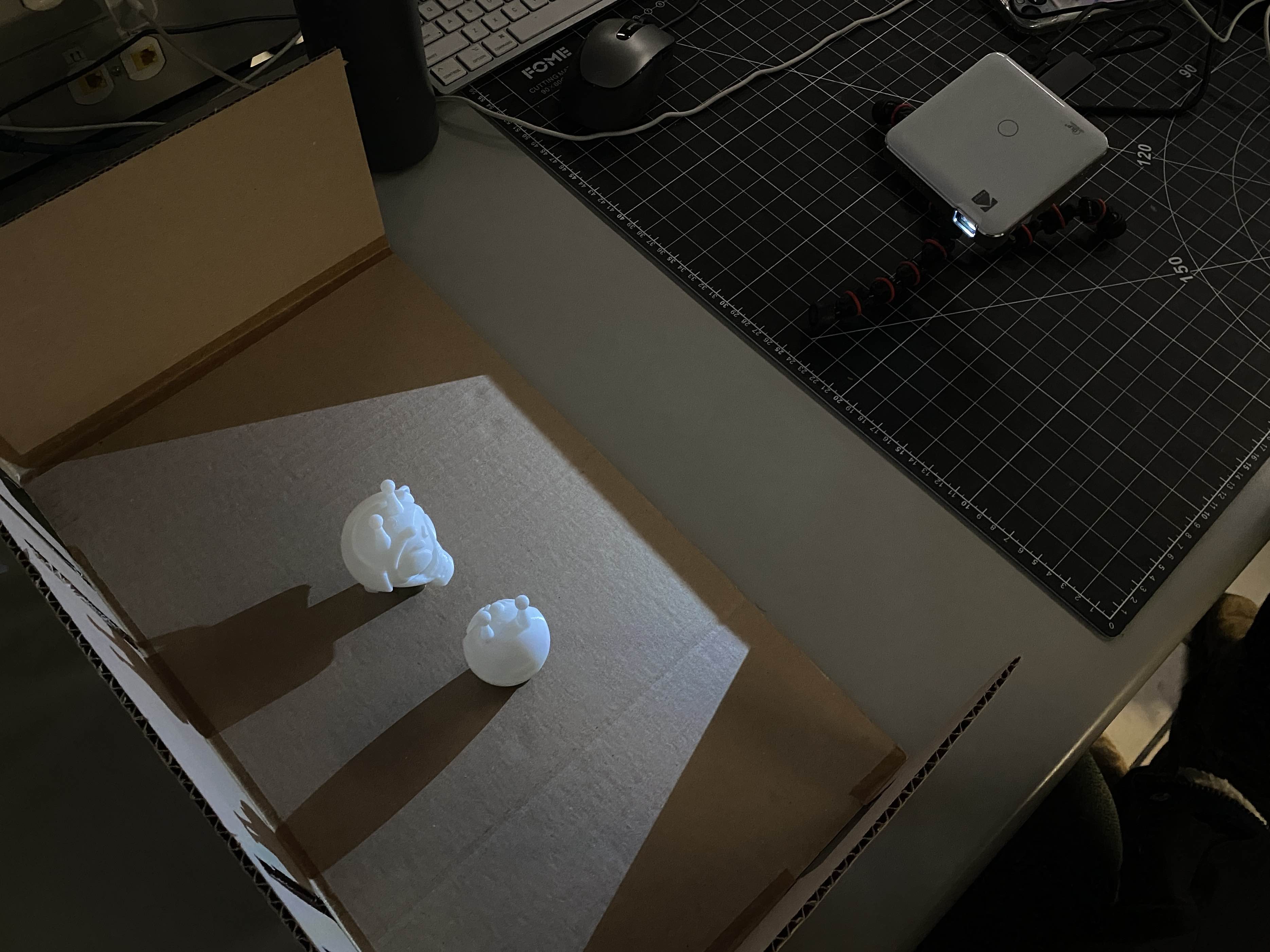 We projected onto the cardboard model using a miniature projector. Although the standing figures are not to scale, they were still useful in visualizing our conceptual experience to our peers.
From this model, we learned that in order to avoid shadow-cast, we would need two projectors; one projecting overhead and one projecting on the wall, mounted on the truss in the Marquee.